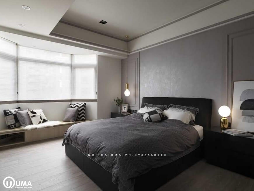 Chiếc giường ngủ được sử dụng với bộ chăn ga gối đệm màu nâu xám đặt giữa phòng